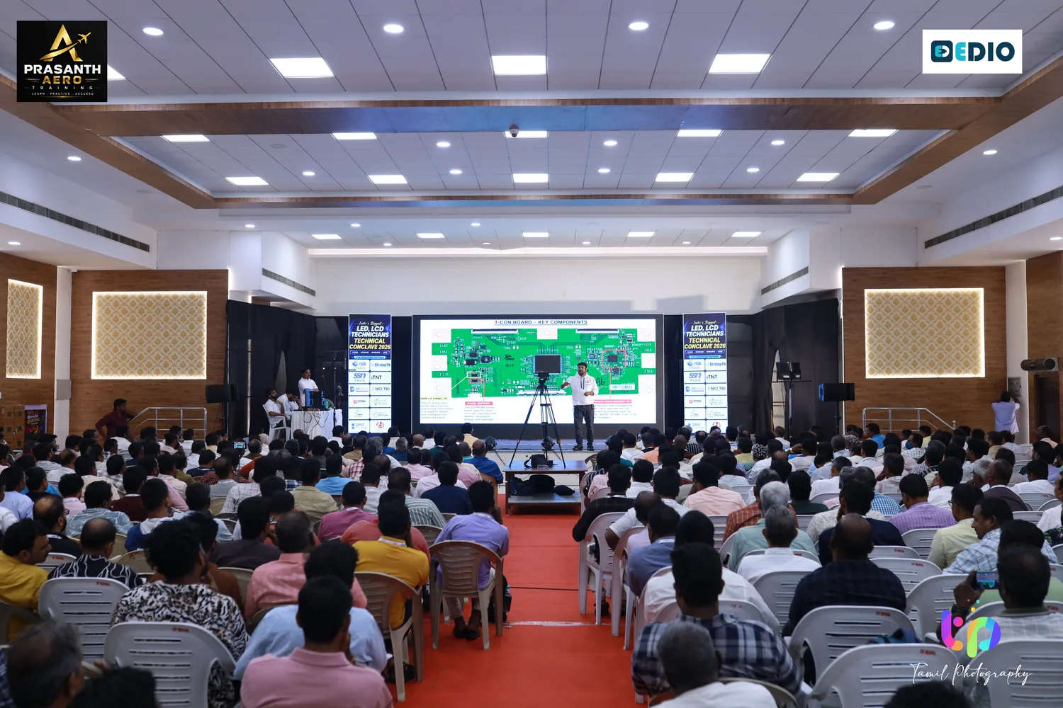 எலக்ட்ரானிக் ரிப்பேர் டெக் சம்மிட்டில் தொலைக்காட்சி டெக்னீஷியன்களால் நிரம்பிய அரங்கம்.